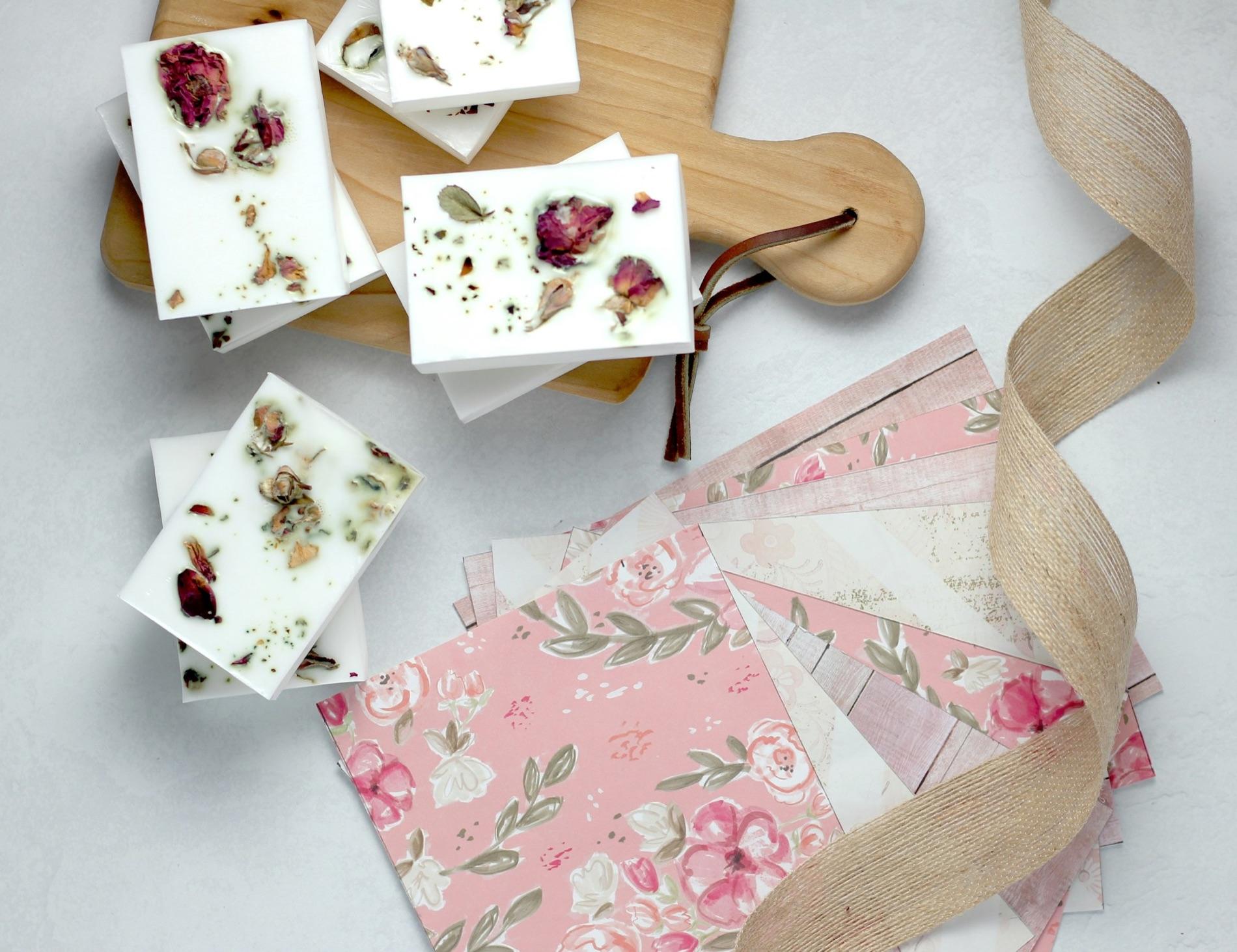 Soap bars set with dried rose petals, laid out on a workbench